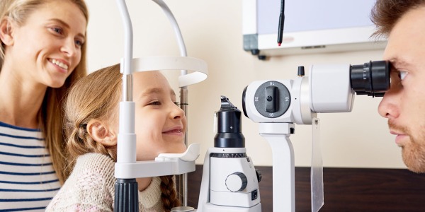 Girl having her eyes checked by eye doctor